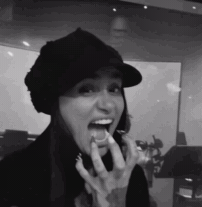 A Black And White Photo Of A Woman Eating Something GIF