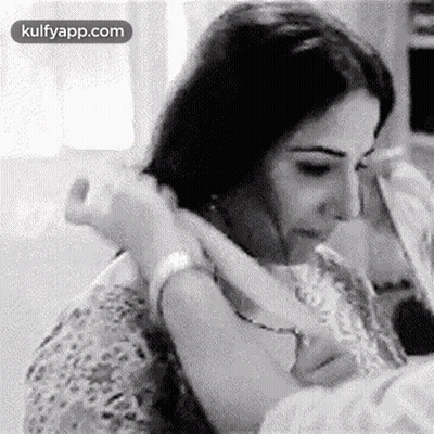 A Black And White Photo Of A Woman Holding A Baby . GIF