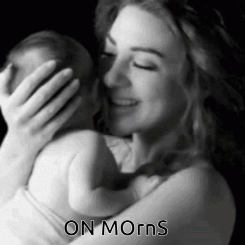 A Black And White Photo Of A Woman Holding A Baby With The Words " On Morns " Below Her GIF