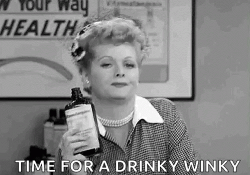 A Black And White Photo Of A Woman Holding A Bottle Of Liquor And Saying `` Time For A Drinky Winky '' . GIF