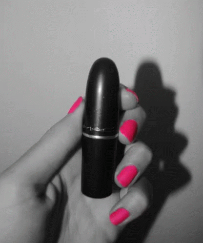 A Black And White Photo Of A Woman Holding A Lipstick GIF