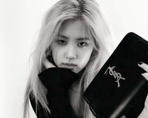 A Black And White Photo Of A Woman Holding A Purse That Says Yves Saint Laurent GIF