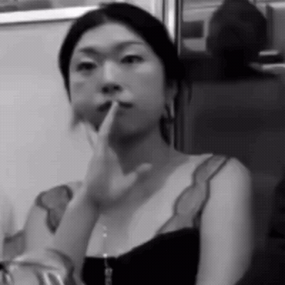 A Black And White Photo Of A Woman Holding Her Finger To Her Lips GIF