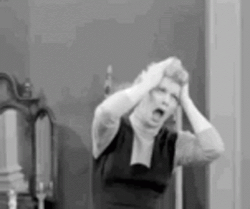 A Black And White Photo Of A Woman Holding Her Head In A Room . GIF