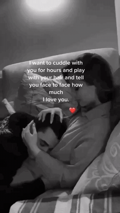 A Black And White Photo Of A Woman Hugging A Man On A Couch .. GIF
