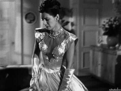 A Black And White Photo Of A Woman In A Dress And Gloves Taken By Nitratediva GIF