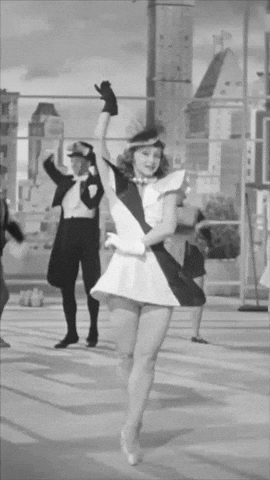 A Black And White Photo Of A Woman In A Dress Dancing GIF