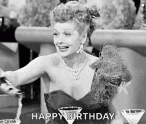 A Black And White Photo Of A Woman In A Dress Holding A Martini Glass And Saying Happy Birthday . GIF