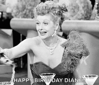 A Black And White Photo Of A Woman In A Dress Sitting At A Table With Two Martini Glasses And A Necklace . GIF