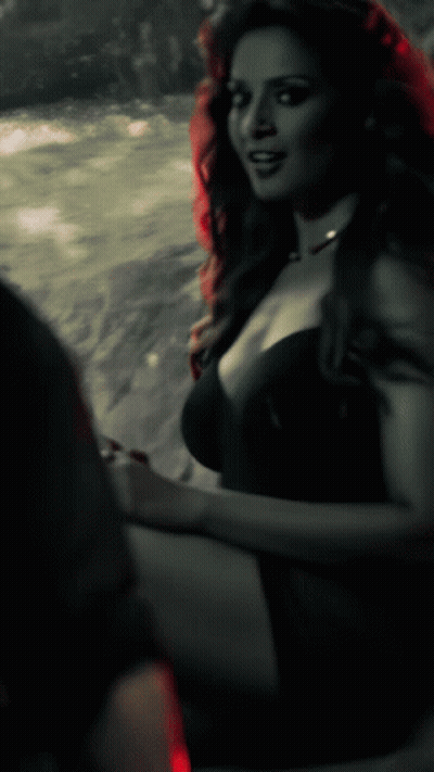 A Black And White Photo Of A Woman In A Plunging Black Dress GIF