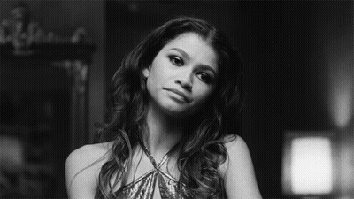 A Black And White Photo Of A Woman In A Sequined Dress Looking At The Camera . GIF
