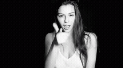 A Black And White Photo Of A Woman In A Tank Top Making A Funny Face . GIF