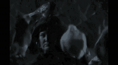 A Black And White Photo Of A Woman In A Witch Hat Holding A Candle . GIF