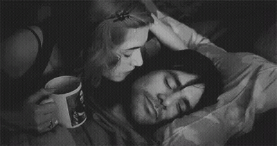 A Black And White Photo Of A Woman Kissing A Man On The Cheek . GIF
