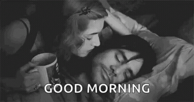 A Black And White Photo Of A Woman Kissing A Man On The Cheek . GIF