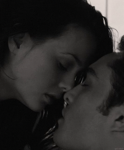 A Black And White Photo Of A Woman Kissing A Man On The Forehead GIF