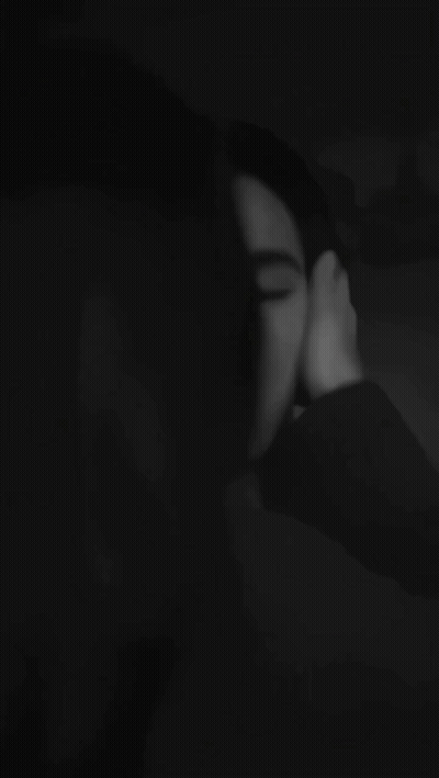 A Black And White Photo Of A Woman Kissing A Man 'S Forehead . GIF