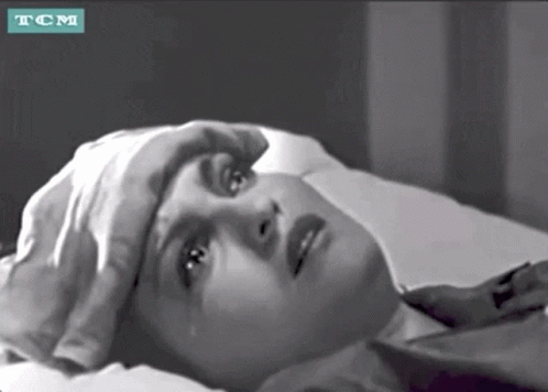 A Black And White Photo Of A Woman Laying In Bed With A Tcm Logo GIF