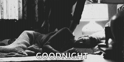 A Black And White Photo Of A Woman Laying On A Bed With The Words `` Goodnight '' Above Her . GIF