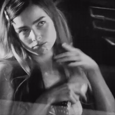 A Black And White Photo Of A Woman Looking At Herself In The Mirror GIF