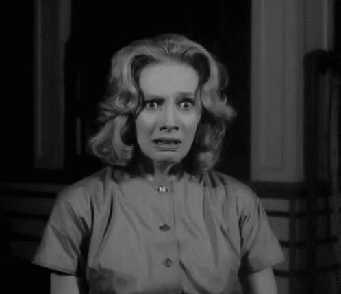 A Black And White Photo Of A Woman Making A Scared Face . GIF