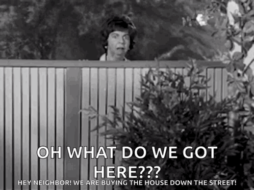A Black And White Photo Of A Woman Peeking Over A Fence With The Words `` Oh What Do We Got Here ? '' GIF
