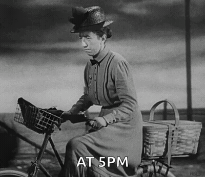 A Black And White Photo Of A Woman Riding A Bike With The Words At 5Pm Written Below Her GIF