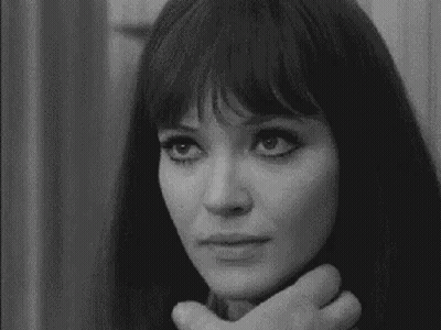A Black And White Photo Of A Woman 'S Face With A Hand On Her Neck . GIF