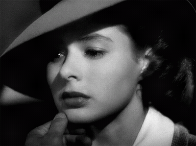 A Black And White Photo Of A Woman 'S Face With A Hat On GIF