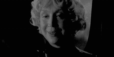 A Black And White Photo Of A Woman 'S Face With A Serious Look On Her Face . GIF