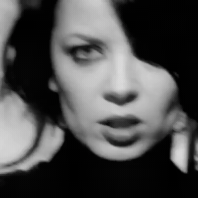 A Black And White Photo Of A Woman 'S Face With A Serious Look On Her Face . GIF