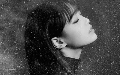 A Black And White Photo Of A Woman 'S Face With Her Eyes Closed In The Snow . GIF