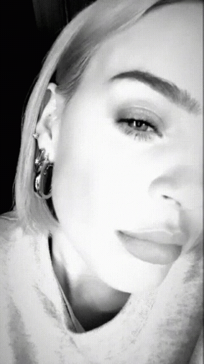 A Black And White Photo Of A Woman 'S Face With Hoop Earrings GIF