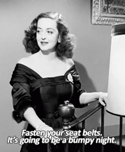 A Black And White Photo Of A Woman Saying " Fasten Your Seat Belts It 'S Going To Be Bumpy Night " GIF