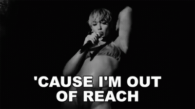 A Black And White Photo Of A Woman Singing Into A Microphone In A Bikini . GIF