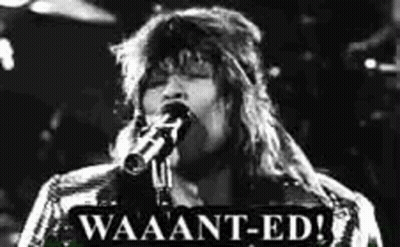 A Black And White Photo Of A Woman Singing Into A Microphone With A Sign That Says Waaant-Ed . GIF
