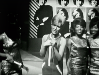 A Black And White Photo Of A Woman Singing Into A Microphone With Mbs Written On The Bottom GIF