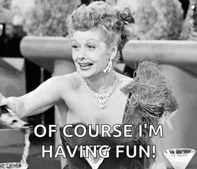 A Black And White Photo Of A Woman Sitting At A Table With A Martini Glass And A Feather Boa . GIF