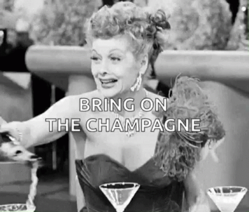 A Black And White Photo Of A Woman Sitting At A Table With Martini Glasses And Champagne . GIF