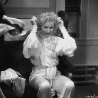 A Black And White Photo Of A Woman Sitting On A Chair With The Caption Nitratediva GIF