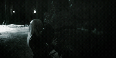A Black And White Photo Of A Woman Standing In The Dark GIF