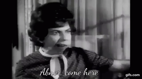 A Black And White Photo Of A Woman Talking To Another Woman In A Room . GIF