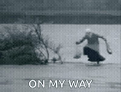 A Black And White Photo Of A Woman Walking On The Ice With The Words `` On My Way '' . GIF