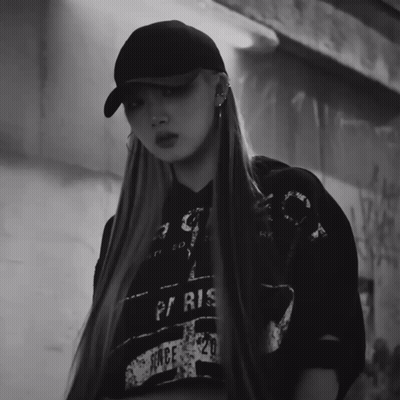 A Black And White Photo Of A Woman Wearing A Hat And A Paris Shirt GIF
