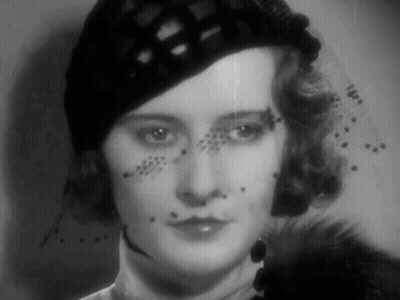 A Black And White Photo Of A Woman Wearing A Hat And A Veil GIF