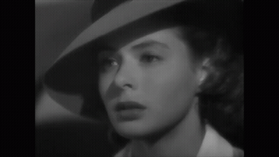 A Black And White Photo Of A Woman Wearing A Hat And A White Shirt GIF