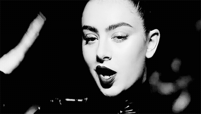 A Black And White Photo Of A Woman Wearing A Leather Jacket And Lipstick . GIF