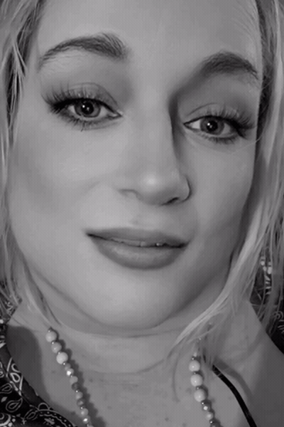 A Black And White Photo Of A Woman Wearing A Necklace GIF