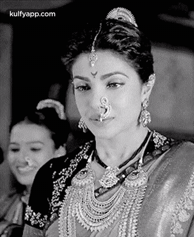A Black And White Photo Of A Woman Wearing A Nose Ring And A Necklace . GIF