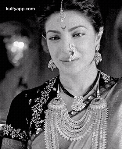 A Black And White Photo Of A Woman Wearing A Nose Ring And Earrings . GIF